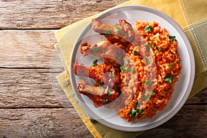 Nigerian food party: Jollof rice with fried chicken wings close-up. Horizontal top view