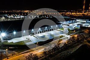 Night Aerial view of goods warehouse. Logistics center in industrial city zone from above. Aerial view of trucks loading at