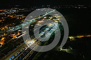night aerial view over long railway freight trains with lots of wagons stand on parking