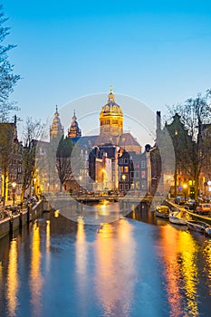 Night in Amsterdam with the Basilica of St. Nicholas in Amsterdam city, Netherlands