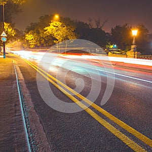 Night asphalt road in the city with car light trails