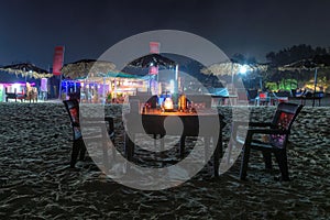 Night beach party in cafe with bottle of rose wine and glasses in GOA, India