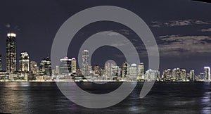 Night blue  hour photography of Jersey City shoreline with the Goldman Sachs office tower in the center.