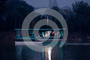 night boat trip on landmark sukhna lake in chandigarh with dark waters of the lake and lights on the boat for a romantic