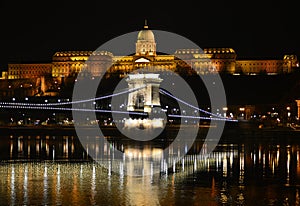 Night Budapest, Chain bridge on the background of Buda Castle, reflection of night lights on the water