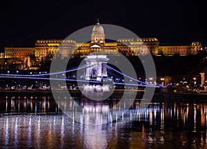 Night Budapest, Chain bridge on the background of Buda Castle, reflection of night lights on the water