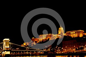 Night Budapest, glowing in gold. The chain bridge over the Danube is illuminated by light bulbs. photo from the river