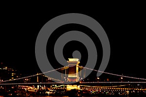 Night Budapest, glowing in gold. The chain bridge over the Danube is illuminated by light bulbs. photo from the river