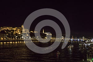 Night Budapest at the river Danube. Buda Castle Royal Palace and Chain bridge Szechenyi lanchid on background. Hungary