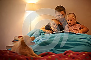 Night, children or father reading book in bed for learning, education or storytelling at home with dog. Family, relax or