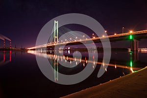 Night city. Beautiful glowing bridge over the river