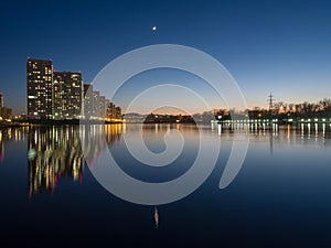 Night city. Houses are reflected in the water