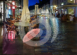 Night city light  pink umbrella  rainy season street    old town of tallinn panorama blurring bokeh city  people walking