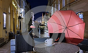 Night  city light  pink umbrella  rainy season street    old town of Tallinn panorama blurring bokeh cup of coffee on table people