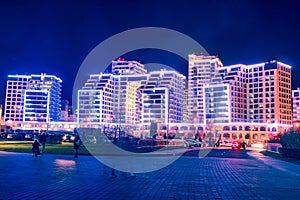 The night city of Minsk shines with bright lights illuminating buildings.