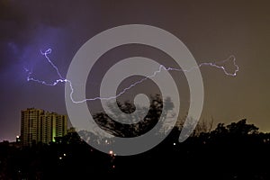 Night city in a storm, lightning and high-rise building