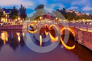 Night city view of Amsterdam canal and bridge photo