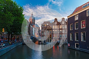 Night city view of Amsterdam canal, church and bridge