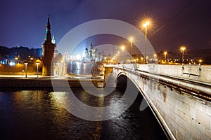 Night cityscape view of Moscow Kremlin, Basil`s Descent and Red Square, embankment, street lights at evening winter snowfall.