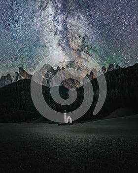 Night clear sky with Milky way and stars over Church St. Johann in Ranui, Dolomites