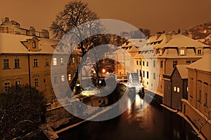 Night colorful romantic snowy Prague Mill above Certovka, Czech republic