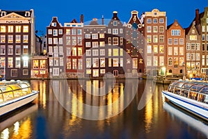 Night dancing houses at Amsterdam canal Damrak, Holland, Netherlands.