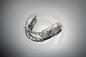 Night dental guard by bruxism on gray background photo