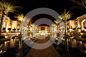 Night Dubai street with palms and pool