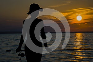 Night evening fishing. Fisherwoman silhouette on sunset landscape