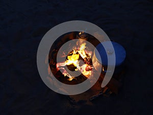 Night fire while heating food in a metal casserole on bonfire in Egypt