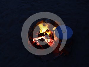 Night fire while heating food in a metal casserole on bonfire in Egypt