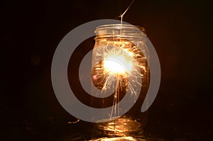 Night fireworks sparkler burning inside glass jar