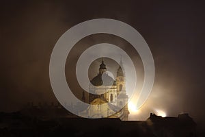 Night fog over Saint Nicholas Church in Prague, Czech Republic.