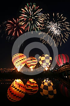 Night glow hot air balloon with beautiful firework