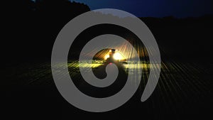 Night harvest illuminating the fields, loading maize into trailers a vital scene