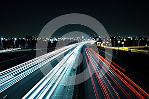 Night Highway Light Trails with Cityscape Background
