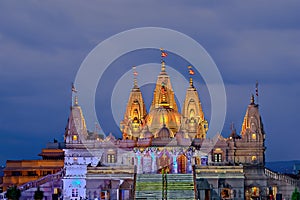 Night illuminated Shree Swaminarayan temple with dark blue cloud. photo