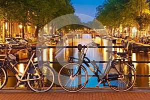 Night illumination of Amsterdam canal and bridge