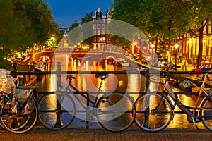 Night illumination of Amsterdam canal and bridge