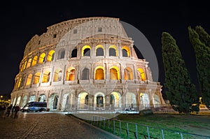 A night image of the Colosseum with stars above. A police van si