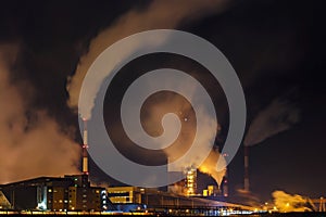 night industrial landscape environmental pollution waste of thermal power plant. Big pipes of chemical industry enterprise plant