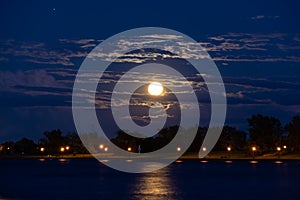 Night landscape with glowing super moon full sturgeon moon in clouds