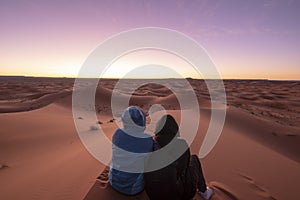 Night landscape with loving couple in the desert near Merzouga, Morocco