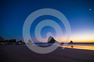 Night landscape of pacific ocean beach in USA, cliffs, and night stars. Beautiful sunset