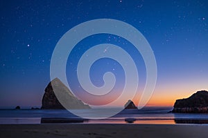 Night landscape of pacific ocean beach in USA, cliffs, and night stars. Beautiful sunset