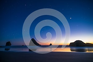 Night landscape of pacific ocean beach in USA, cliffs, and night stars. Beautiful sunset