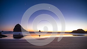 Night landscape on the pacific ocean, Cannon beach. Stars and cliffs, sunset time