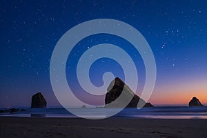 Night landscape on the pacific ocean, Cannon beach. Stars and cliffs, sunset time