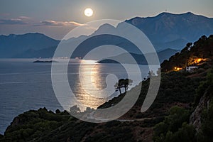 Night landscape with sea, moon, and mountains