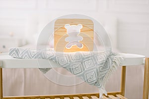 Night lapms and decor. Home interior and cozy accessories. Wooden lamp with bear cut out picture, on table, at beautiful